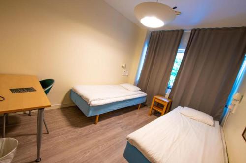 乌普萨拉Vandrarhem Kvarntorget的一间医院间,配有两张床和一张书桌