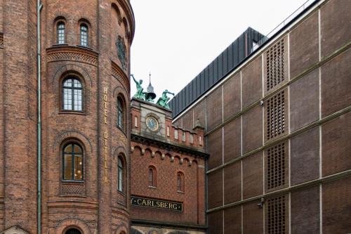 哥本哈根Hotel Ottilia by Brøchner Hotels的一座大型砖砌建筑,上面有钟