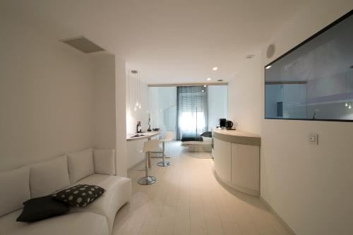 米兰多莫公寓酒店的客厅配有白色沙发和电视