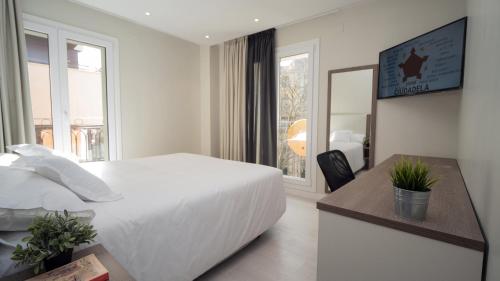 潘普洛纳Hotel Ciudadela Pamplona的白色的卧室设有一张大床和一个窗户