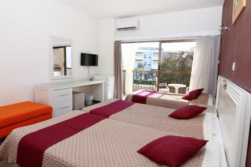 帕福斯国王酒店的酒店客房设有两张床和一个阳台。