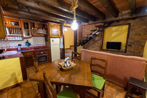 巴列埃尔莫索Casa Rural Abuelo Ramón的厨房以及带木桌的用餐室。