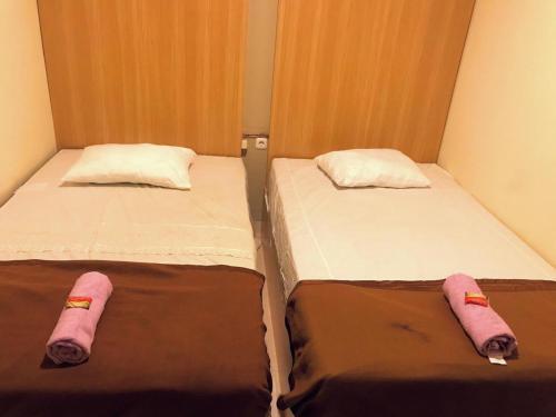 日惹Kangen Yogya Homestay Malioboro Mitra RedDoorz的两张睡床彼此相邻,位于一个房间里