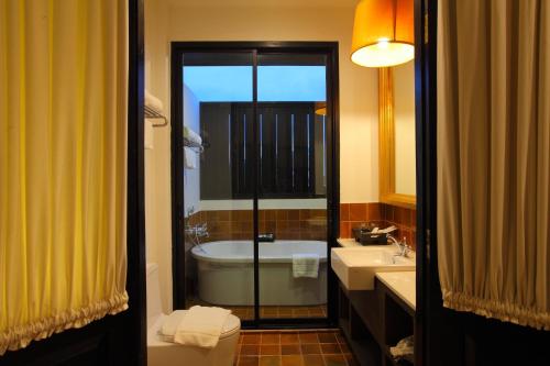 清迈99号画廊酒店- SHA Extra Plus的带浴缸、卫生间和盥洗盆的浴室