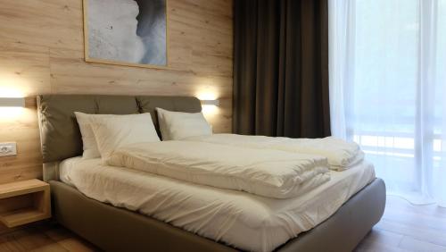 波亚纳布拉索夫Poiana Ski Residence Apartment 5的一张带白色床单和枕头的床