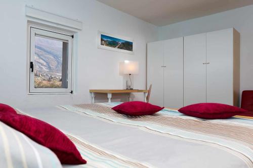 托尔博莱Torbole Holiday House Appartamento con giardino的一间卧室配有两张带红色枕头的床。