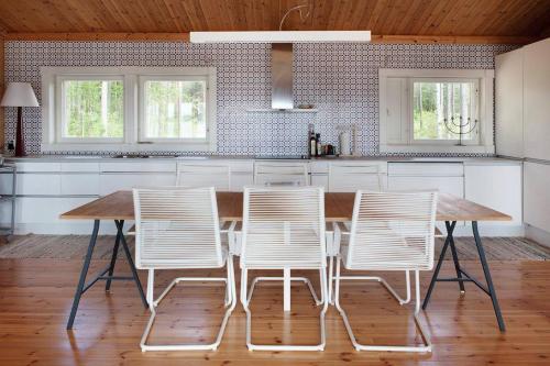 鲁奥科拉赫蒂Utula Nature Retreat的厨房配有木桌和白色椅子