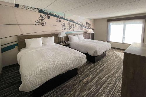 岩石丘Clarion Pointe Near University的酒店客房设有两张床和窗户。