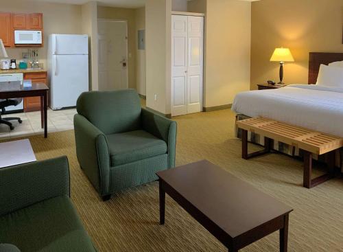 艾迪生MainStay Suites Addison - Dallas的配有床、椅子和桌子的酒店客房
