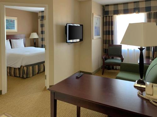 艾迪生MainStay Suites Addison - Dallas的酒店客房设有一张床、一张书桌和一台电视机。