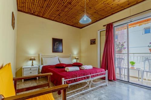卡沃斯Nefeli Mare的一间带红色床的卧室和一个阳台