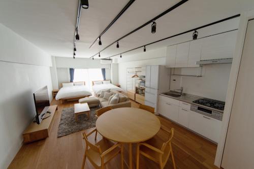 东京NIYS apartments 08 type的厨房以及带桌子和床的客厅。