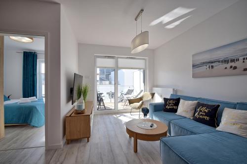 科沃布热格Apartament Nadmorskie Tarasy SPA Deluxe的客厅配有蓝色的沙发和桌子