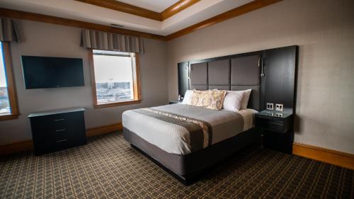 哥伦比亚voco The Tiger Hotel, Columbia, MO, an IHG Hotel的一间卧室配有一张大床和一台平面电视