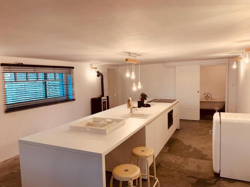Frasnes-lez-AnvaingMMGhome的厨房配有白色的柜台和凳子