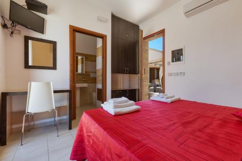 丽都玛里尼Lido Marini Rooms的一间卧室配有红色的床和毛巾