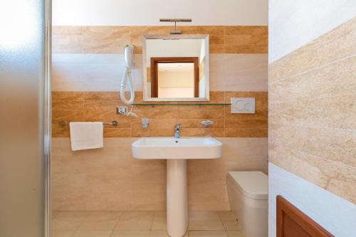 丽都玛里尼Lido Marini Rooms的一间带水槽、镜子和卫生间的浴室
