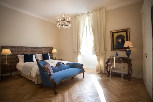 坎波巴索GMarconi Suites的一间卧室配有一张床和一张蓝色椅子