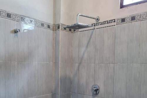 BanjarbaruKrisan Guest House Syariah Mitra RedDoorz的带淋浴喷头的浴室
