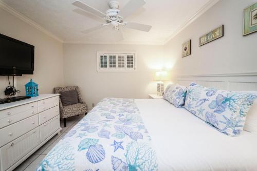 德斯坦狭长地带自助游珊瑚礁俱乐部度假酒店的一间卧室配有一张床和吊扇