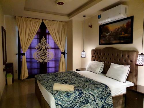 拉瓦尔品第The Millenial Apartments & Suites Bahria Town的一间卧室设有一张大床和一个窗户。