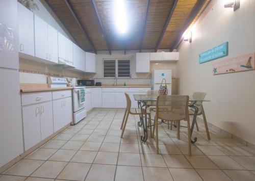 Punta SantiagoChalet Olas del Sol的厨房配有白色橱柜和桌椅