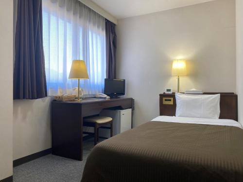 松本松本潮流酒店的酒店客房配有一张床和一张带电脑的书桌