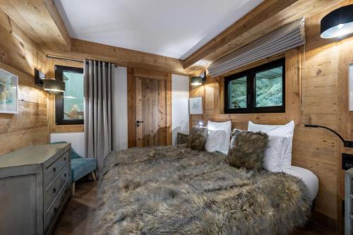瓦勒迪泽尔Penthouse Best View - Les Chalets COVAREL的一间卧室设有一张大床和木墙