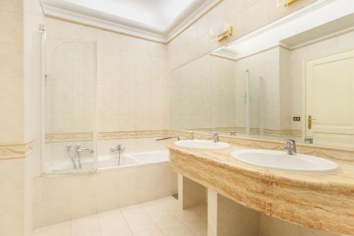 罗马EUR Luminous and Large Family Terrace Apartment的浴室配有2个盥洗盆和1个浴缸。