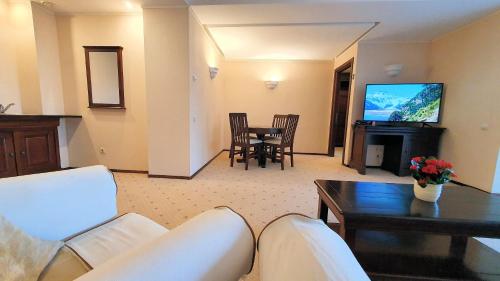 波亚纳布拉索夫Apartament 2706 Alpin Resort, etaj 7, Poiana Brașov的带沙发、桌子和电视的客厅