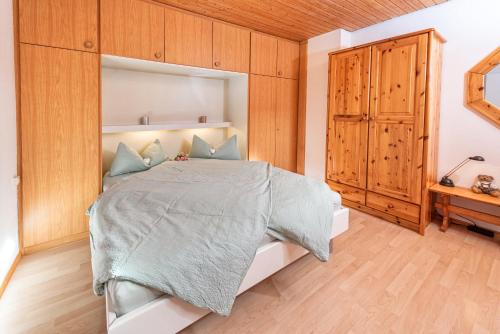 上施陶芬Imberg-Suite mit Schwimmbad的一间卧室配有一张大床和一个木制橱柜