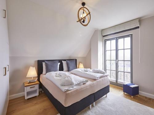 德兰斯克Reetland am Meer - Luxus Reetdachvilla mit 3 Schlafzimmern, Sauna und Kamin E27的一间卧室设有一张大床和一个窗户。