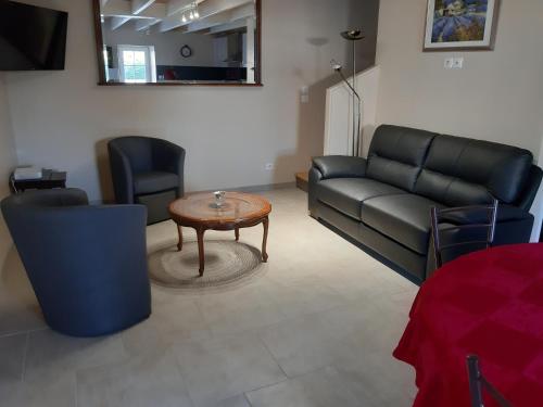 Saint-Sulpice-de-FaleyrensGîte Mimi的客厅配有沙发和桌椅