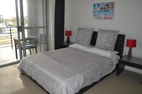 弗里曼特北库基海滩旅馆的一间带大床的卧室和一个阳台
