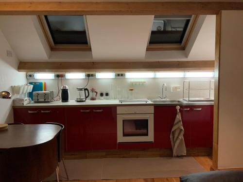 沃金顿Dove Cottage (Annex)的一间带红色橱柜和水槽的厨房