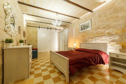 瓦莱塔Sant'Elmo House Valletta的一间卧室设有一张床和石墙