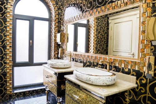 塔什干Level Hotel的一间带两个盥洗盆和大镜子的浴室