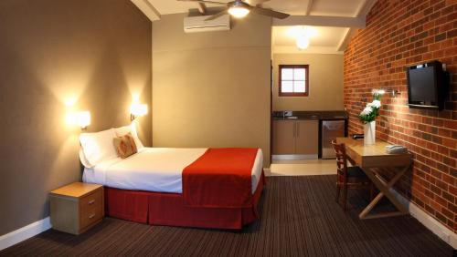 珀斯玫瑰皇冠大酒店的酒店客房,设有床铺和砖墙