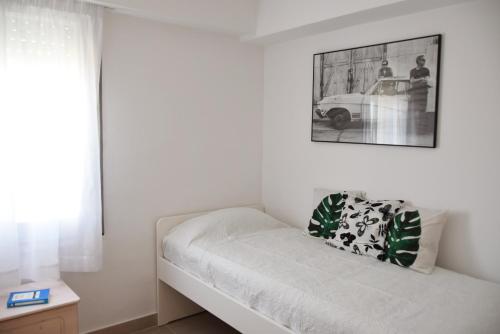 马尔格莱特德玛Apartamento Terraza Mar的白色的房间,配有沙发和墙上的照片