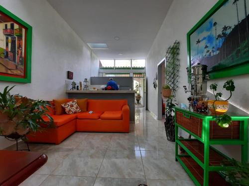 萨兰托Hotel Casa Quinta Salento的一间带橙色沙发的客厅和一间厨房