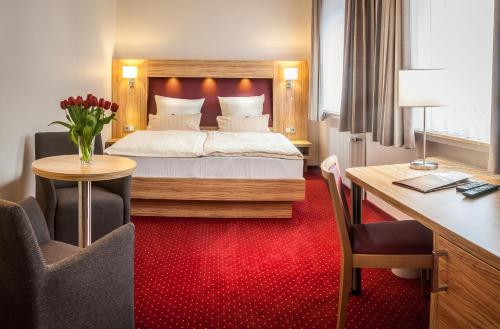 不来梅港城市酒店的酒店客房配有一张床、一张书桌和一张书桌。