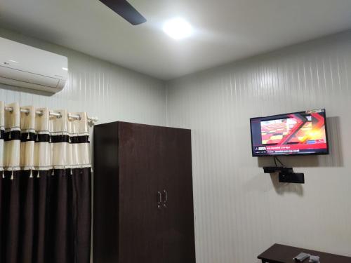特里凡得琅Vidhara Rooms的一间墙上配有电视的房间和一间