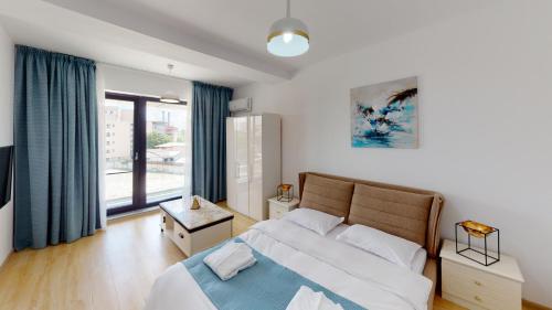 布加勒斯特Le Blanc ApartHotel的一间卧室设有一张床和一个大窗户
