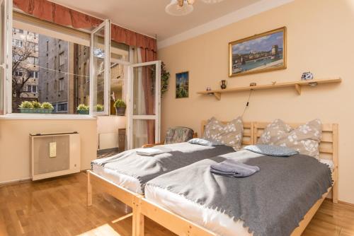 布达佩斯Budaiapertment的一间卧室设有两张床和窗户。
