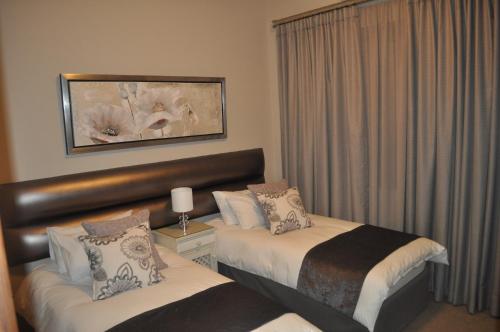 惠灵顿A Perfect Self Catering的酒店客房设有两张床和窗户。