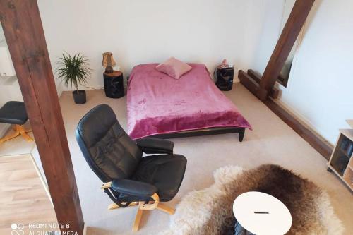 伯根Studiowohnung in Bergen/Bleckmar的一间卧室配有一张床、一把椅子和一张桌子