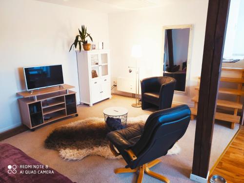 伯根Studiowohnung in Bergen/Bleckmar的客厅配有椅子和电视