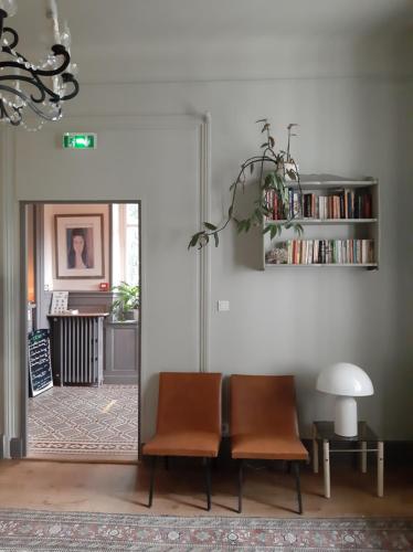 比亚里茨Saint Charles Hôtel & Coliving Biarritz的客厅配有两把椅子和一张桌子