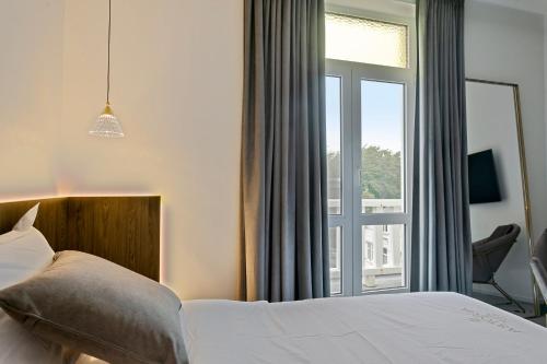 德哈恩Hotel Astoria的一间卧室设有一张床和一个大窗户