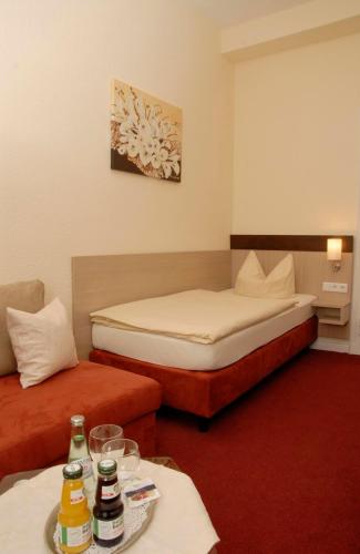 雷姆沙伊德伍珀塔尔霍夫酒店的酒店客房设有两张床和一张桌子。